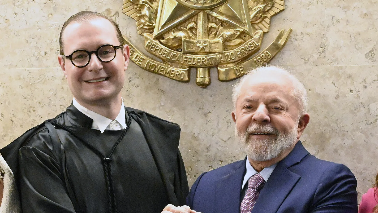 Cristiano Zanin, de toga, ao lado de Lula na posse no STF