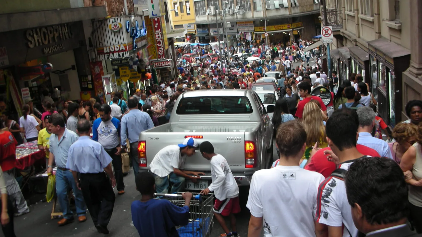Rua 25 de Março, em São Paulo, lotada de pessoas entre lojas