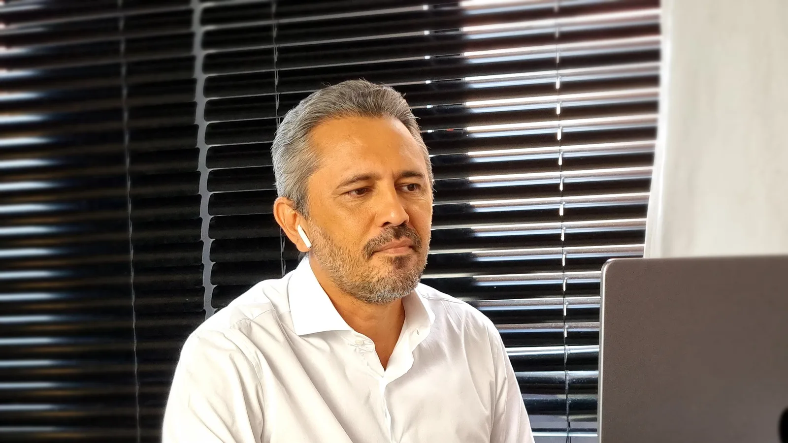 Elmano de Freitas, de camisa branca, sentado diante de um notebook