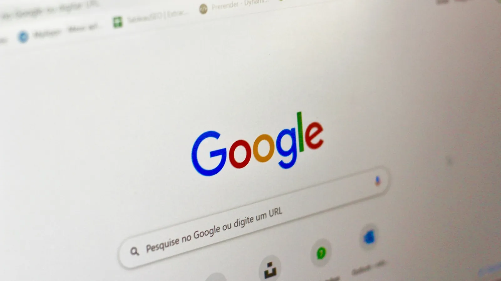 Tela de computador com a página inicial do Google e a barra de pesquisa em português, vista em ângulo