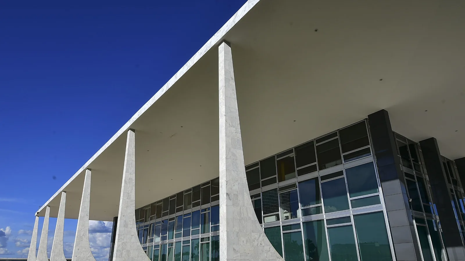 Fachada do Supremo Tribunal Federal, com as colunas curvas, sob céu azul em Brasília